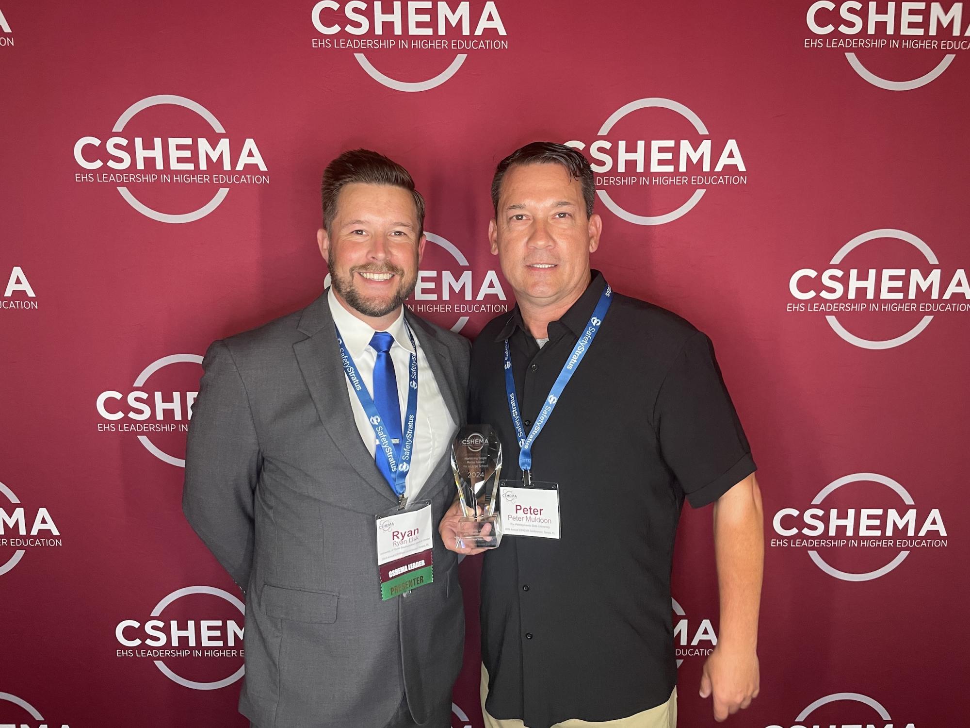 Two people holding an award