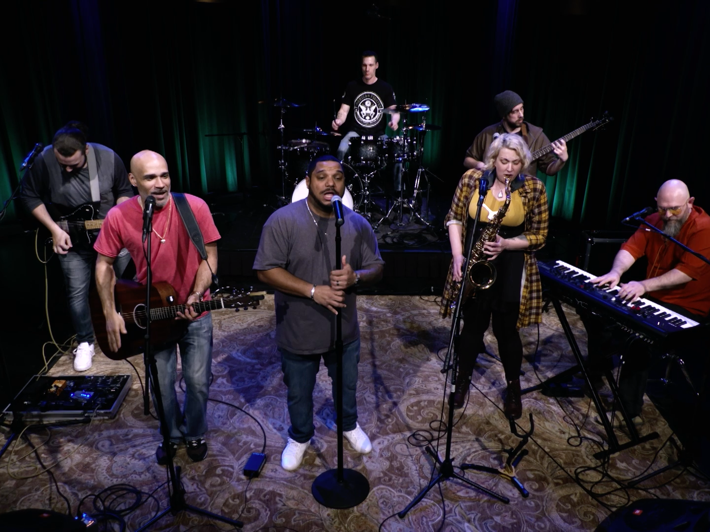 Band members playing instruments on a small stage.