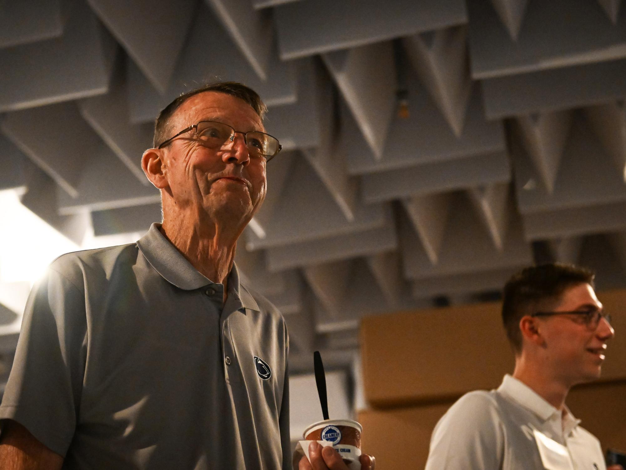 person holds ice cream in research lab with acoustic paneling on ceiling