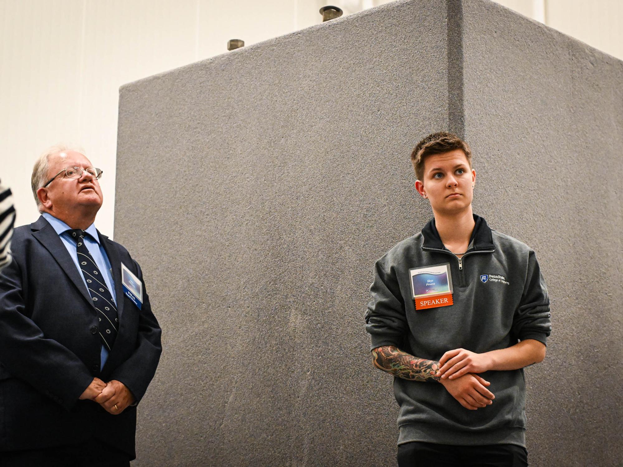  two people stand in front of concrete block designed for mounted turbine testing