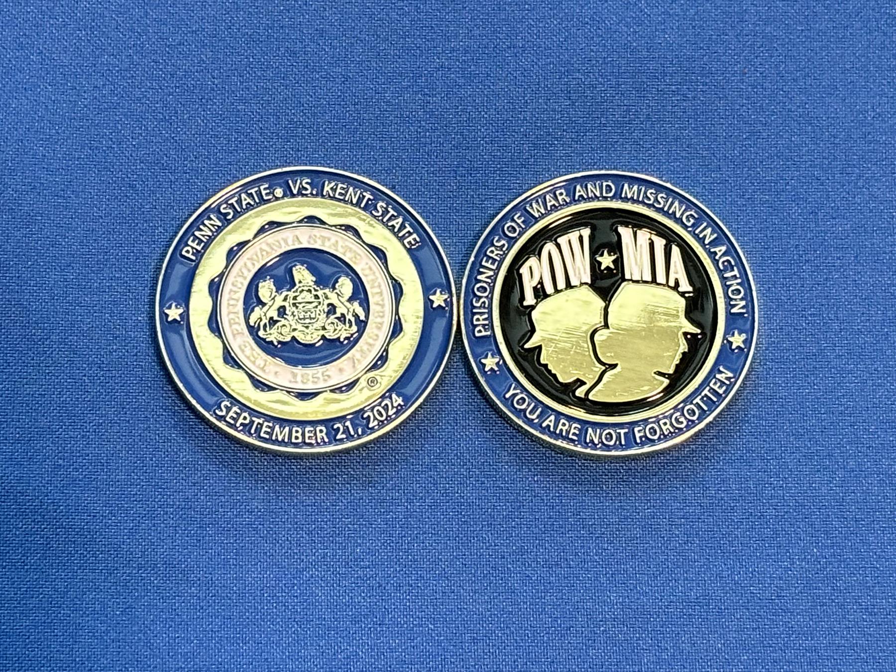 Two military challenge coins on a blue background.