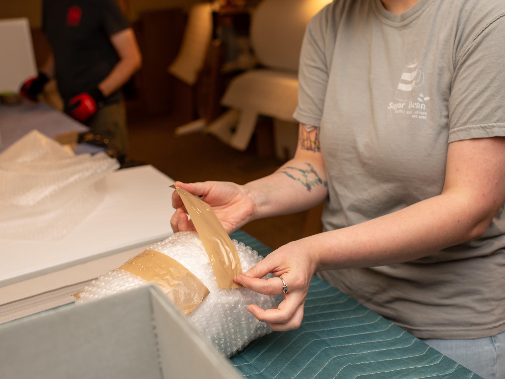 A Matson Museum worker packs an object from its collection. 