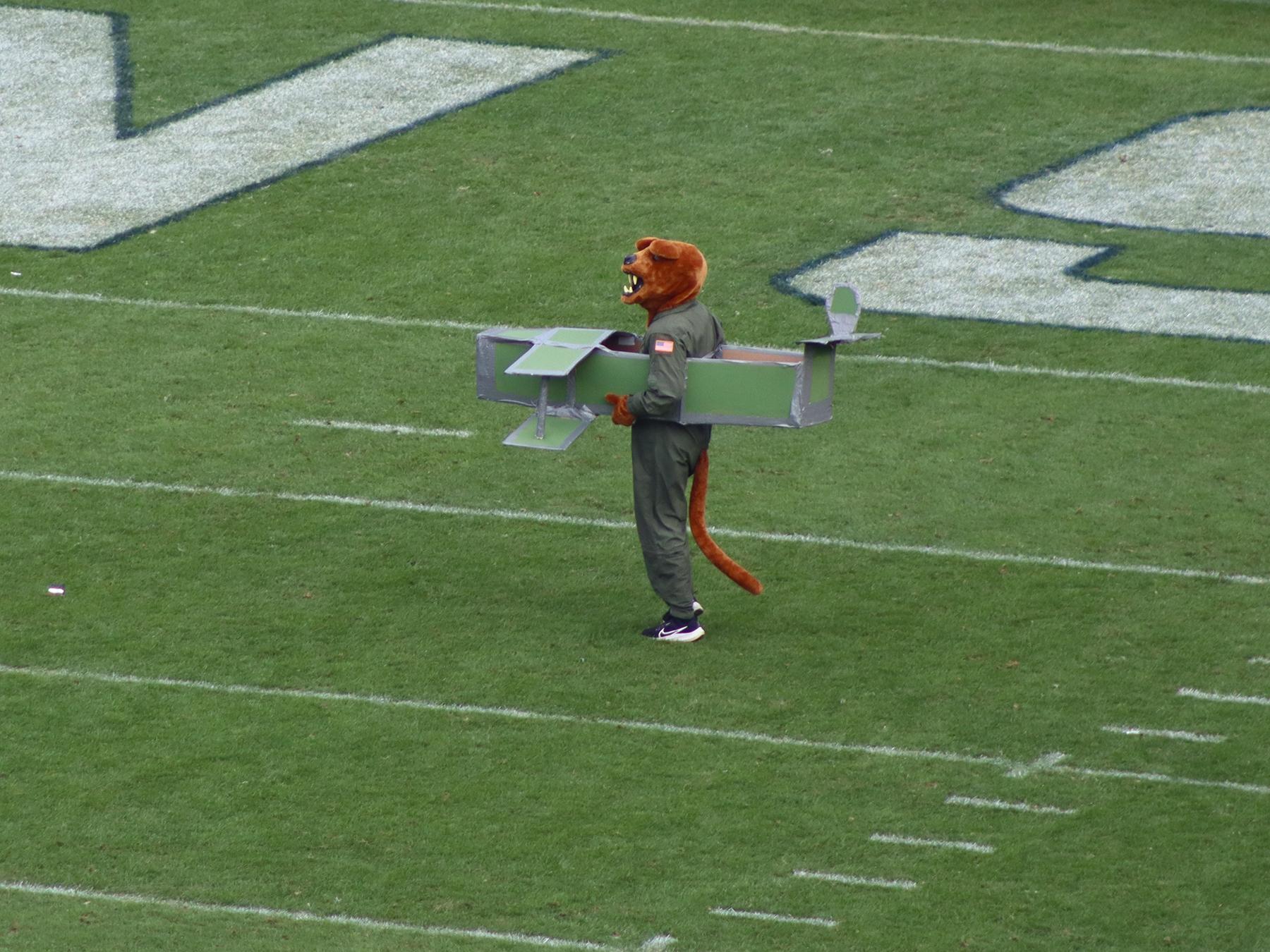 The Nittany Lion mascot wearing a green flight suit and a cardboard airplane.