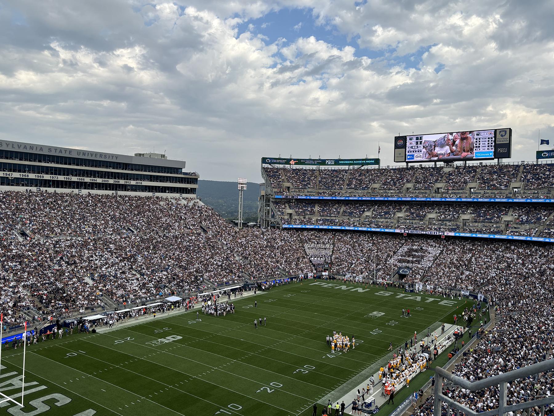 A filled stadium surrounding a football field.