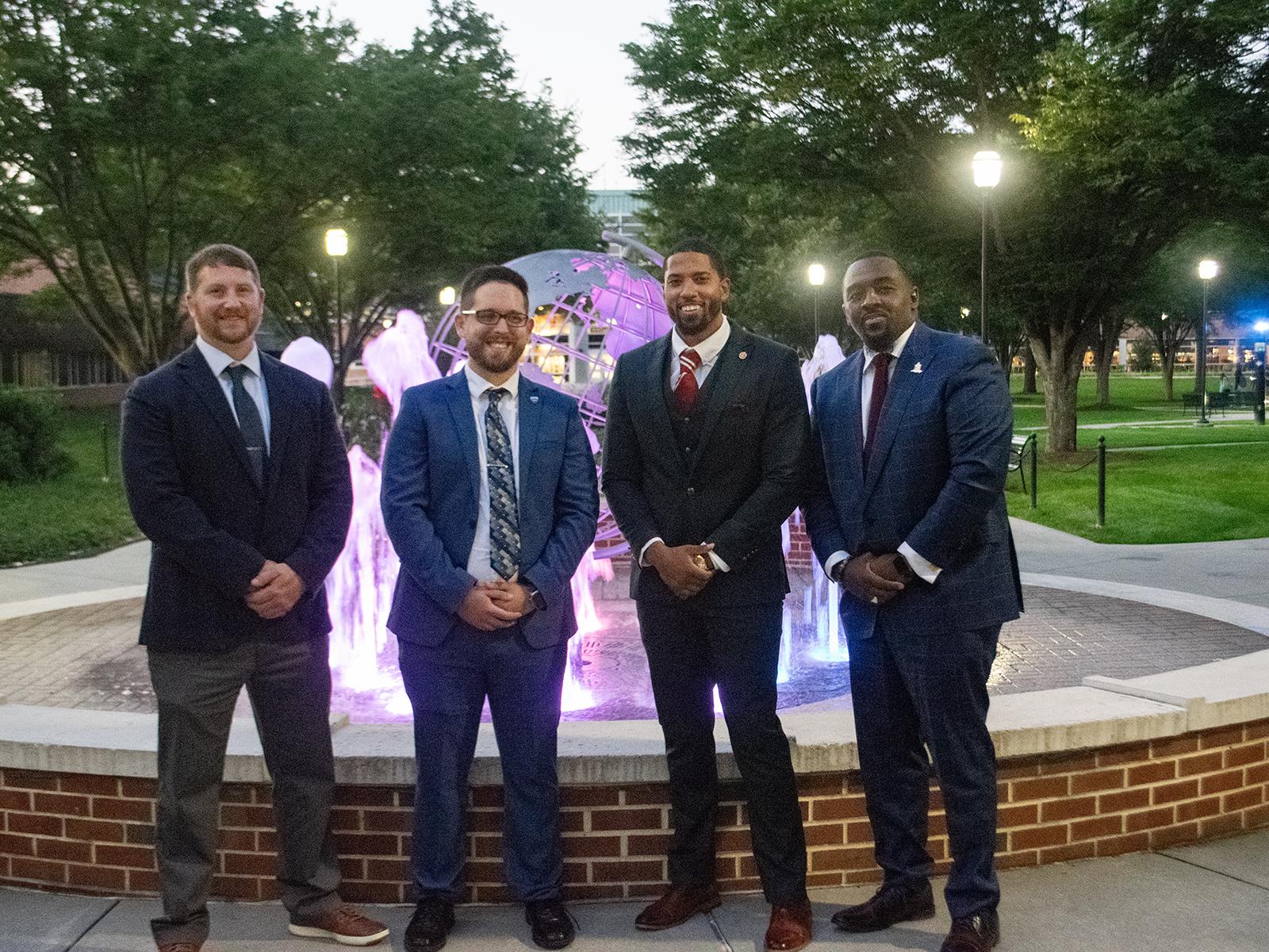 Four recipients of the People to Watch Award gather by the fountain at Penn State Harrisburg