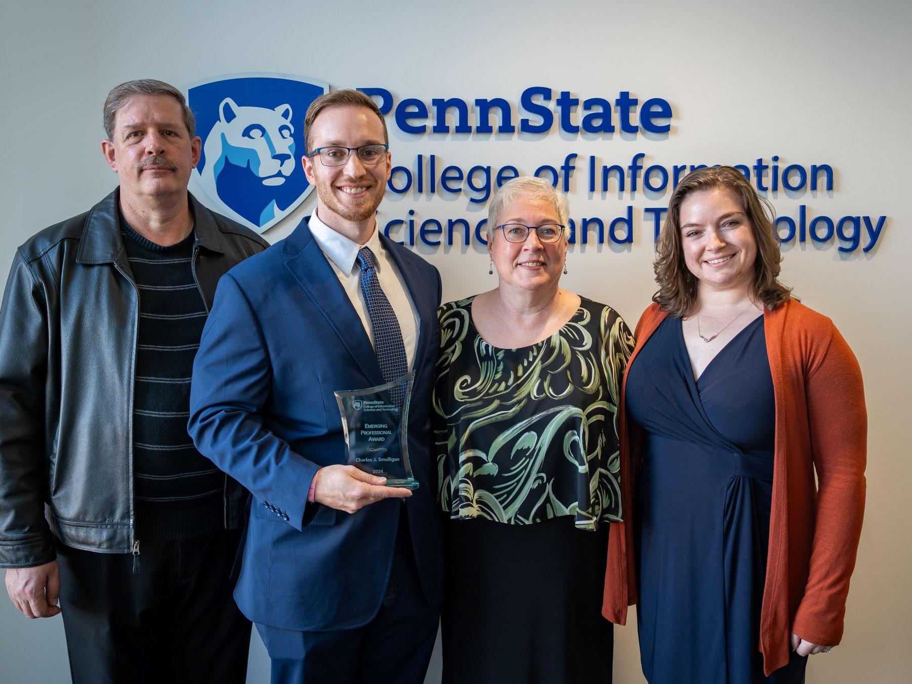 family of four displays award at college event