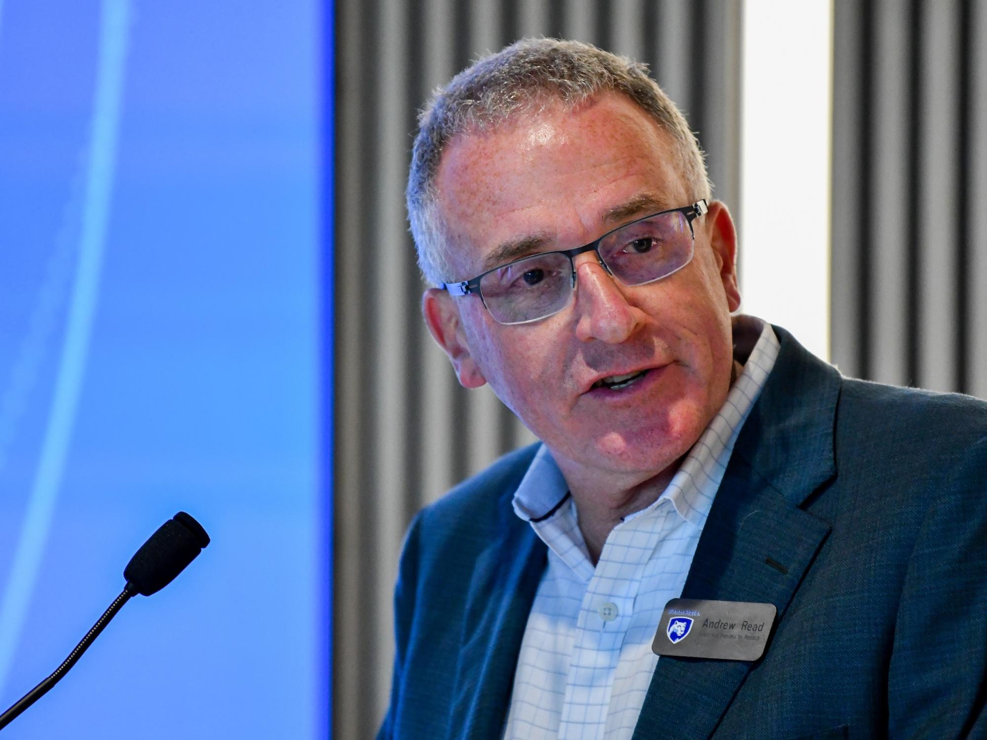 Senior vice President for Research Andrew Read behind microphone
