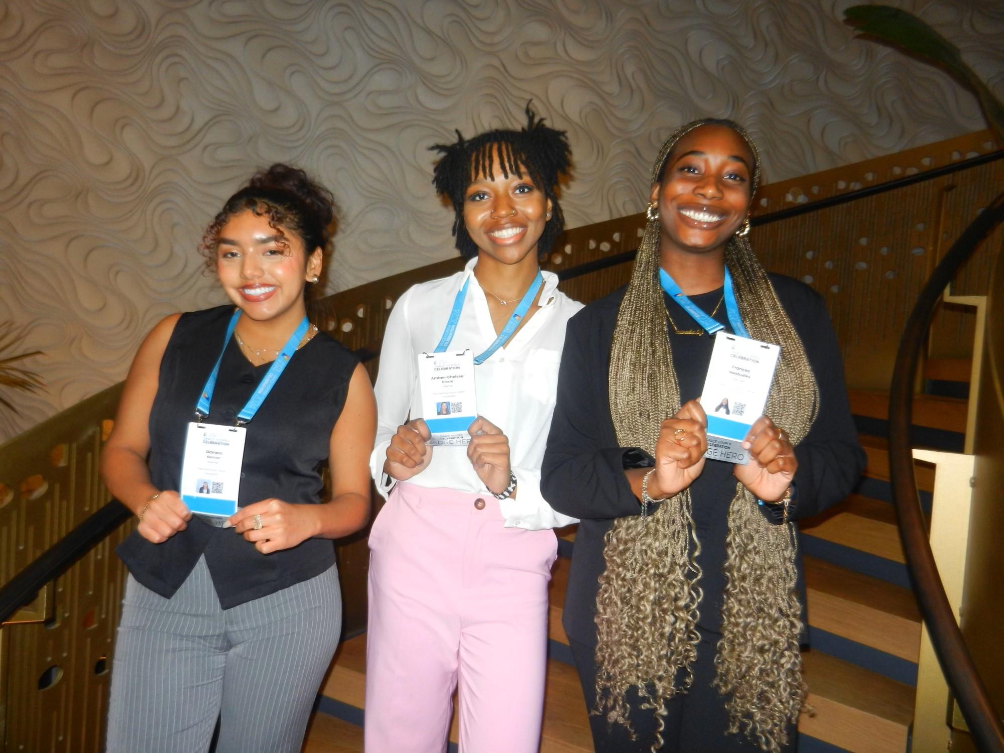 three smiling friends show off their name tags