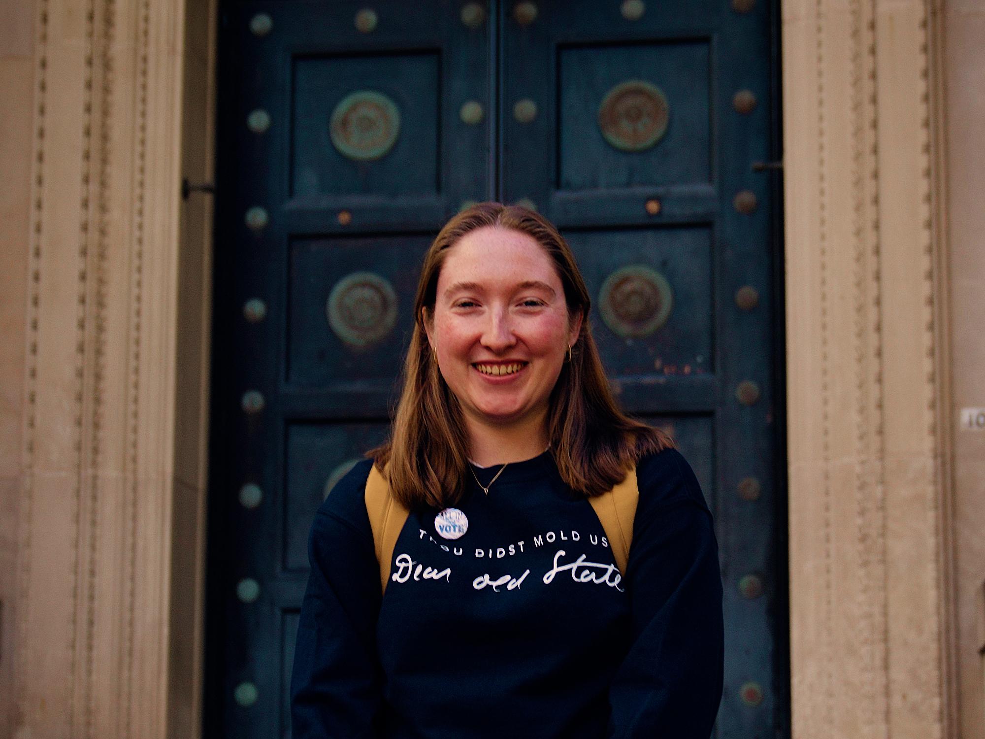 Maddie Hindman stands in front of the main entrance to Sparks Building.