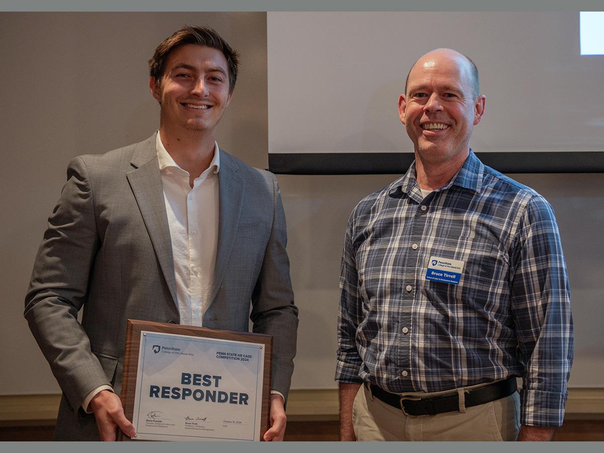 Purdue student Mitchell Curl standing beside Bruce Tirrell after receiving Best Responder Award at HR Case Competition