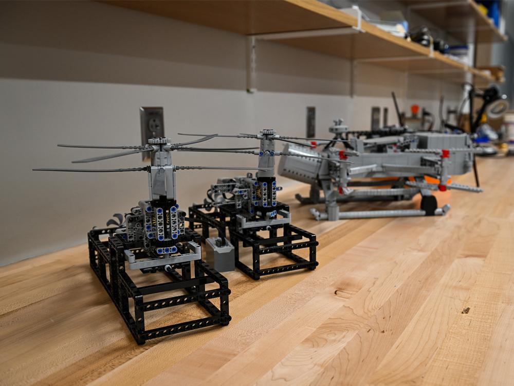 Black and silver LEGO models are displayed on a lab table in an engineering lab.