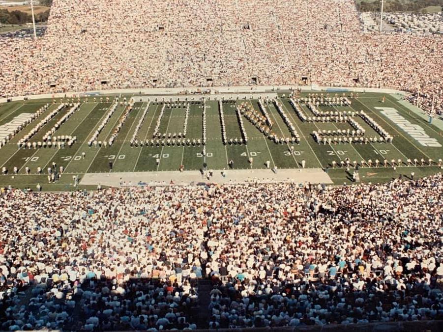 A band forms the word "LIONS" on a football field