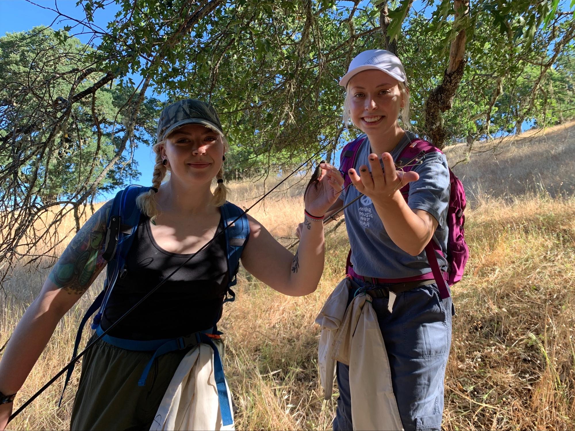 two people holding lizards