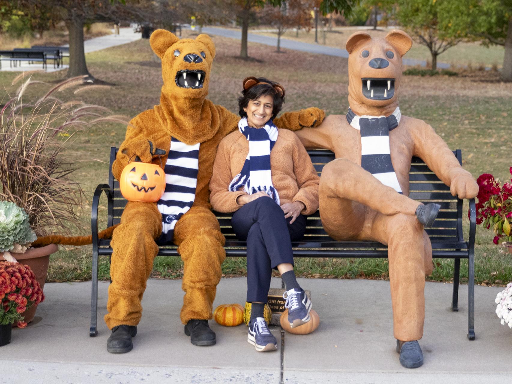 Three Nittany Lions seated on a bench
