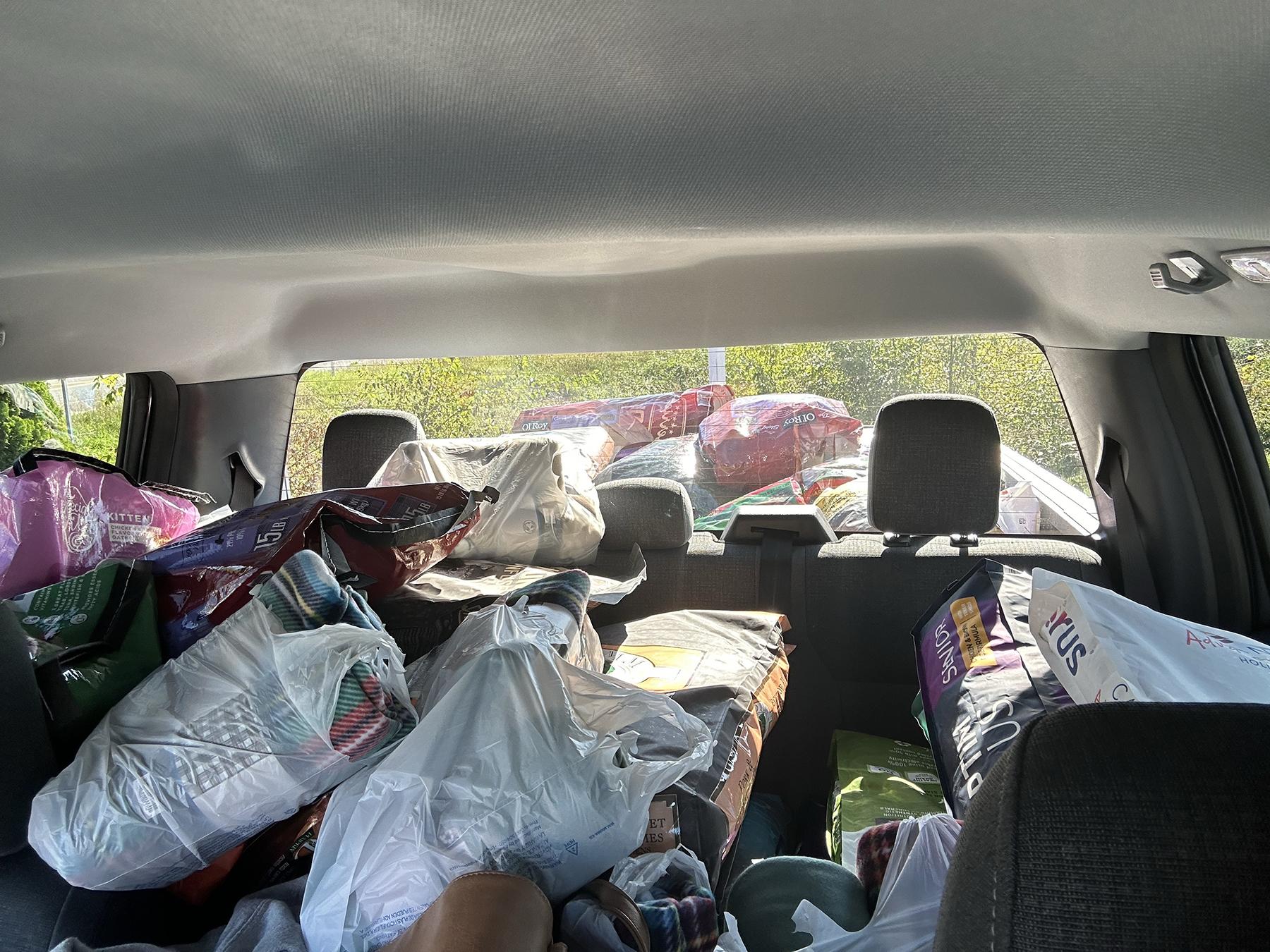 A passenger truck full of donated pet supplies.