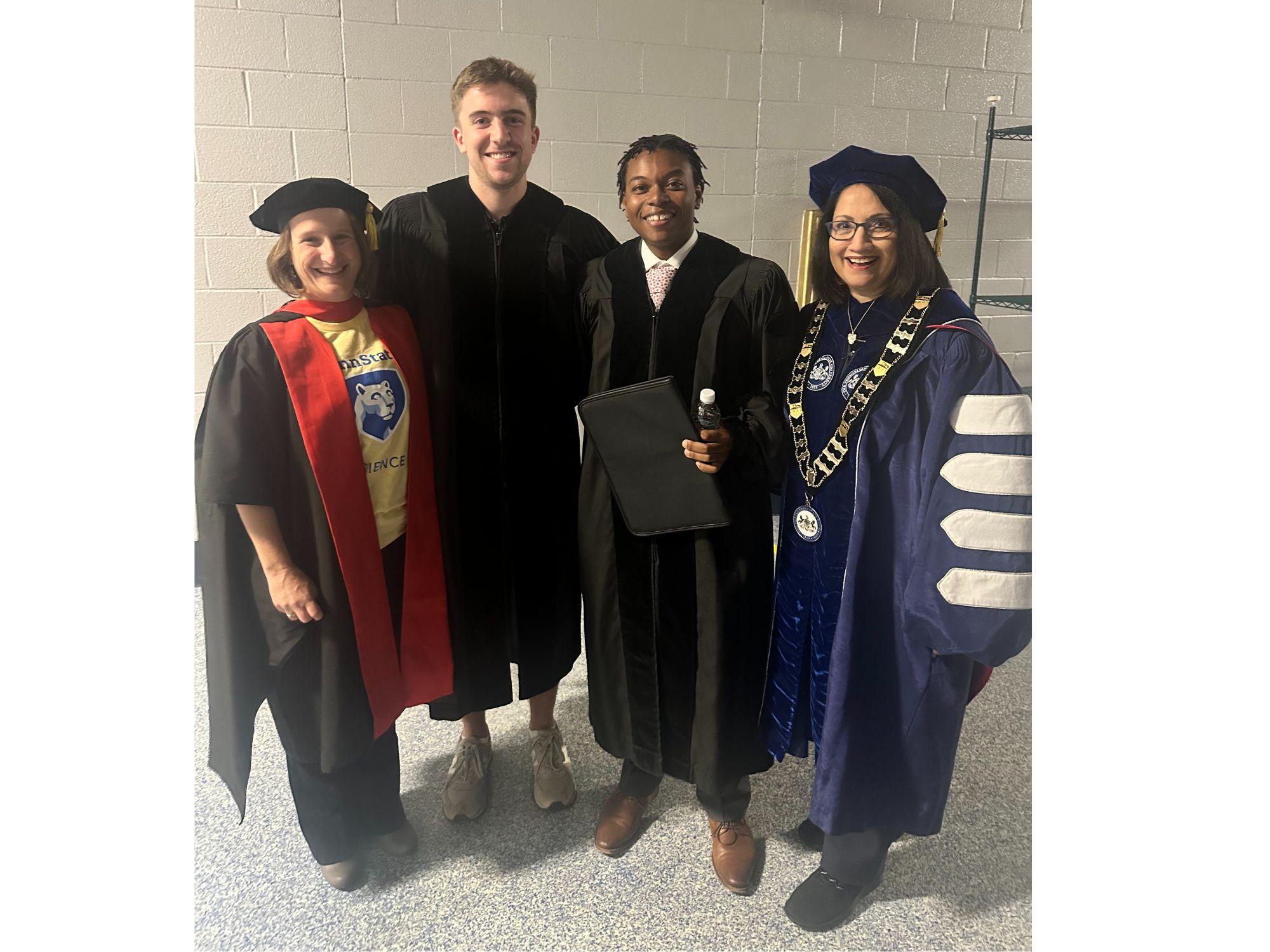 Four individuals pose for the camera at convocation