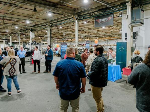 A group of people talking and networking at River Raptor Jet Boats in Belleville, PA