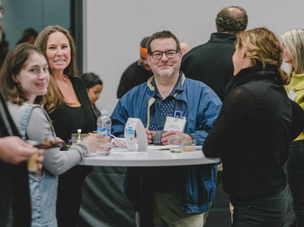People talking and networking at a table during the Community Networking Event