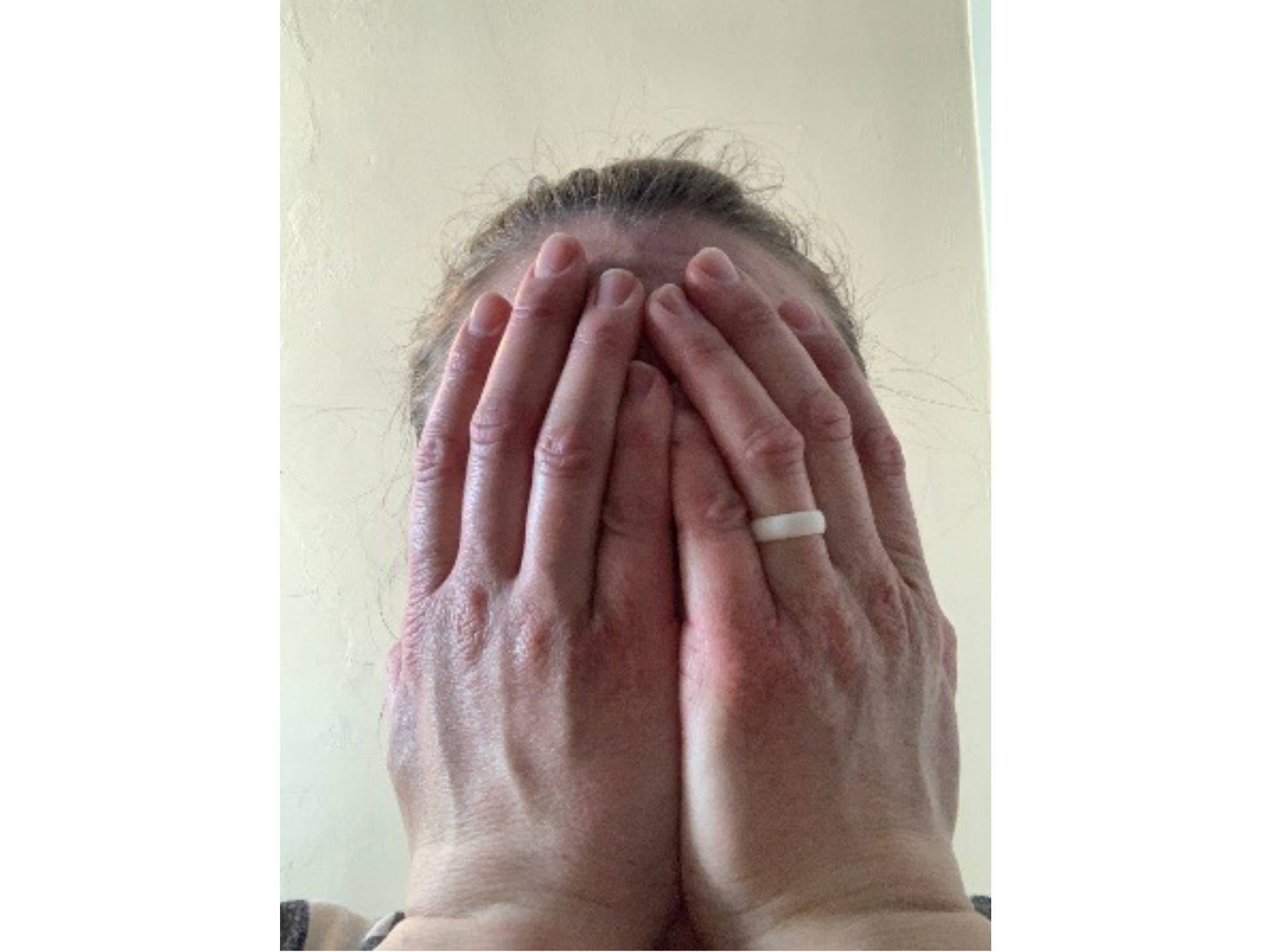 Person with their hands over their face