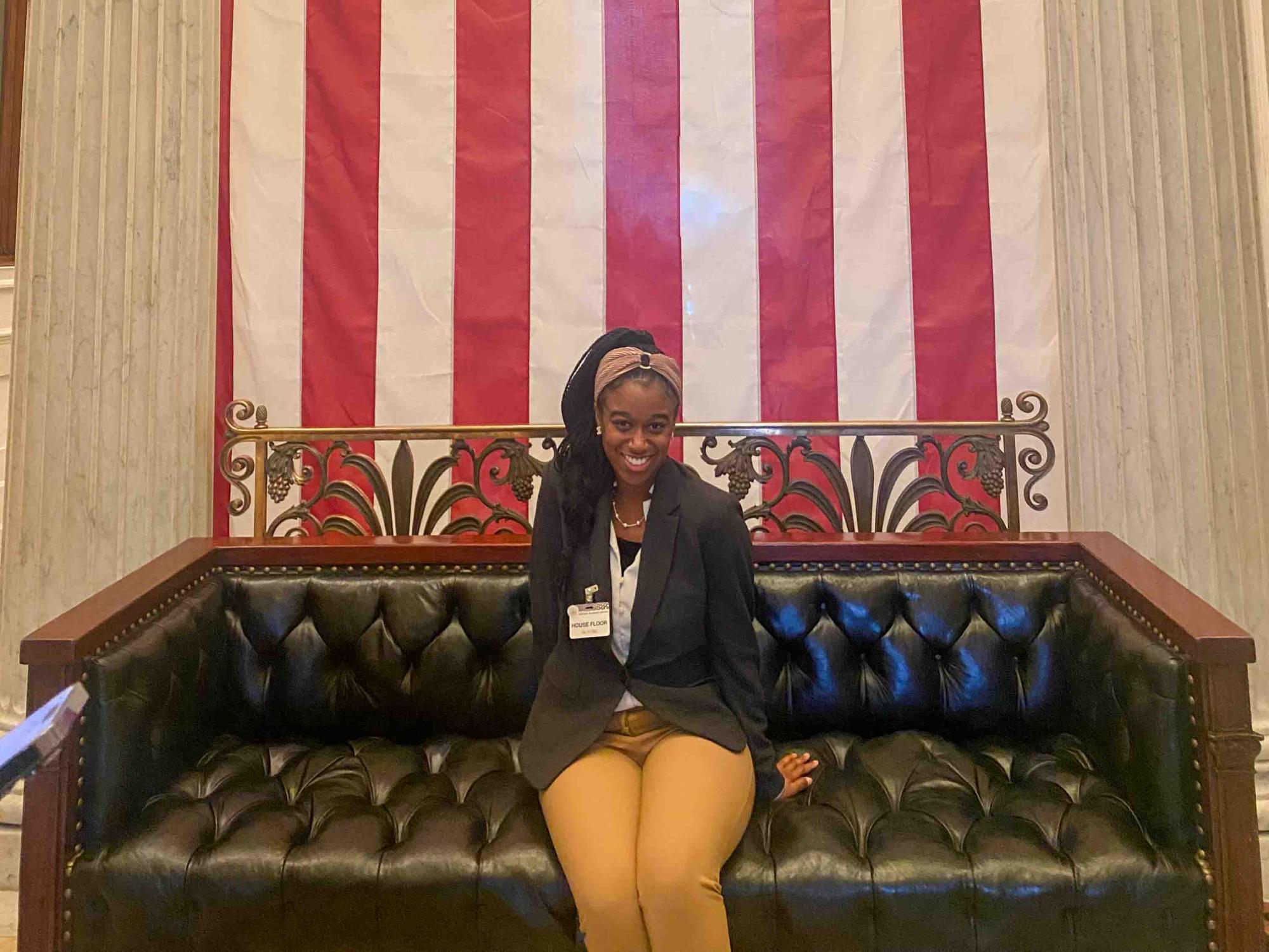 Larkin sits on a bench in front of an American flag while visiting Capitol Hill.