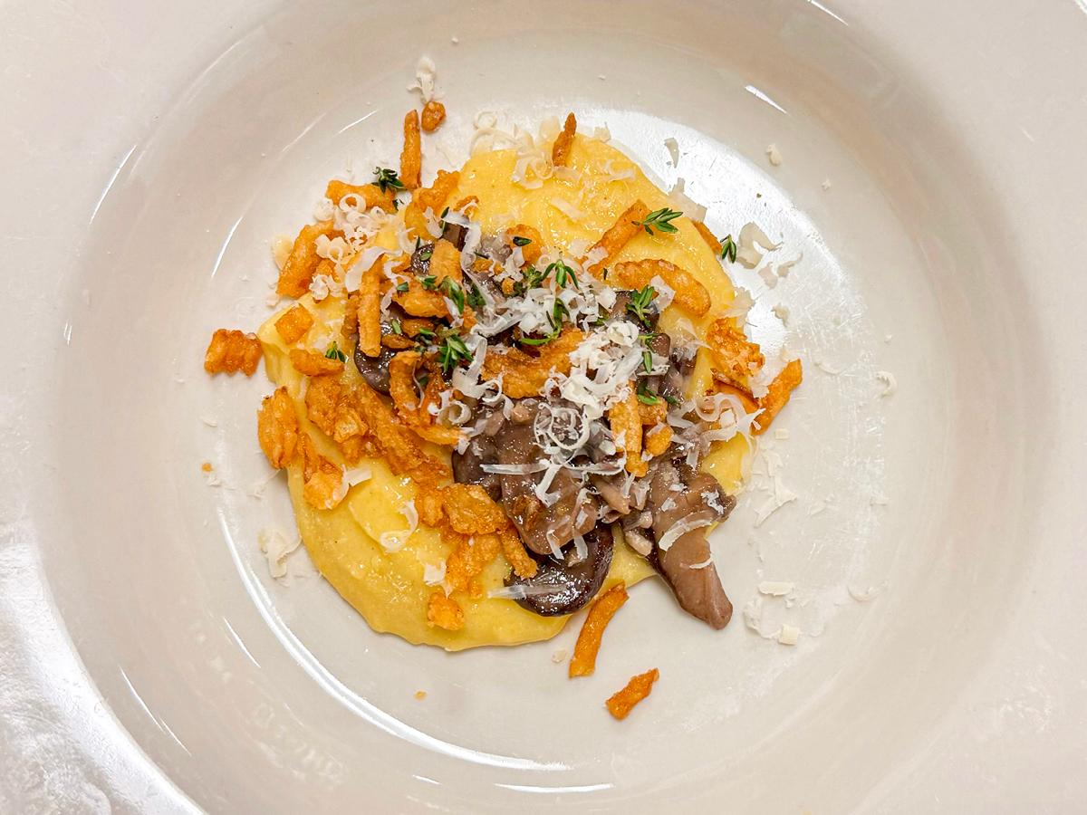Photograph of white plate with polenta, mushrooms, and fried onions with thyme