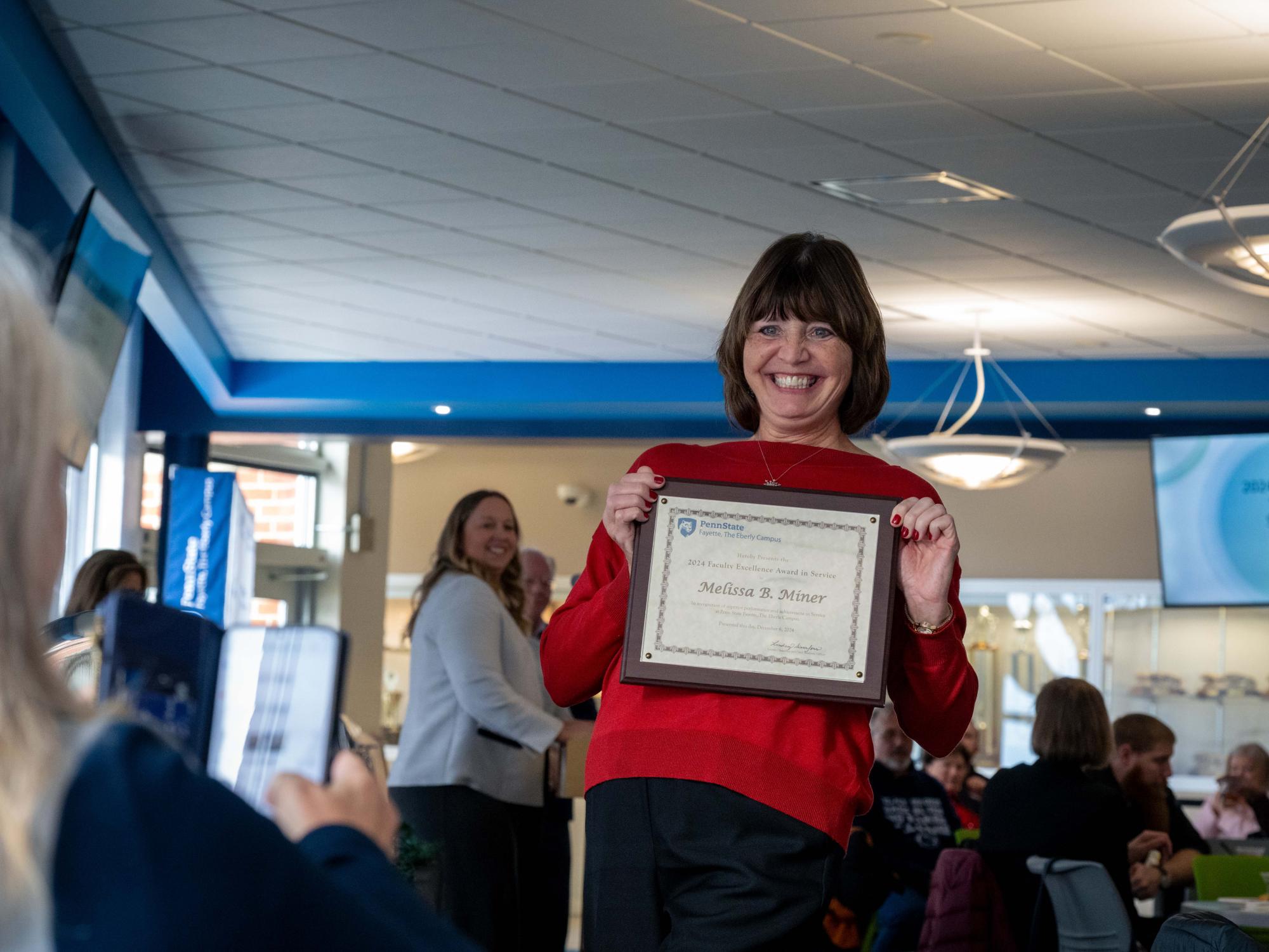 Melissa Miner smiles with her Faculty Excellence Award.