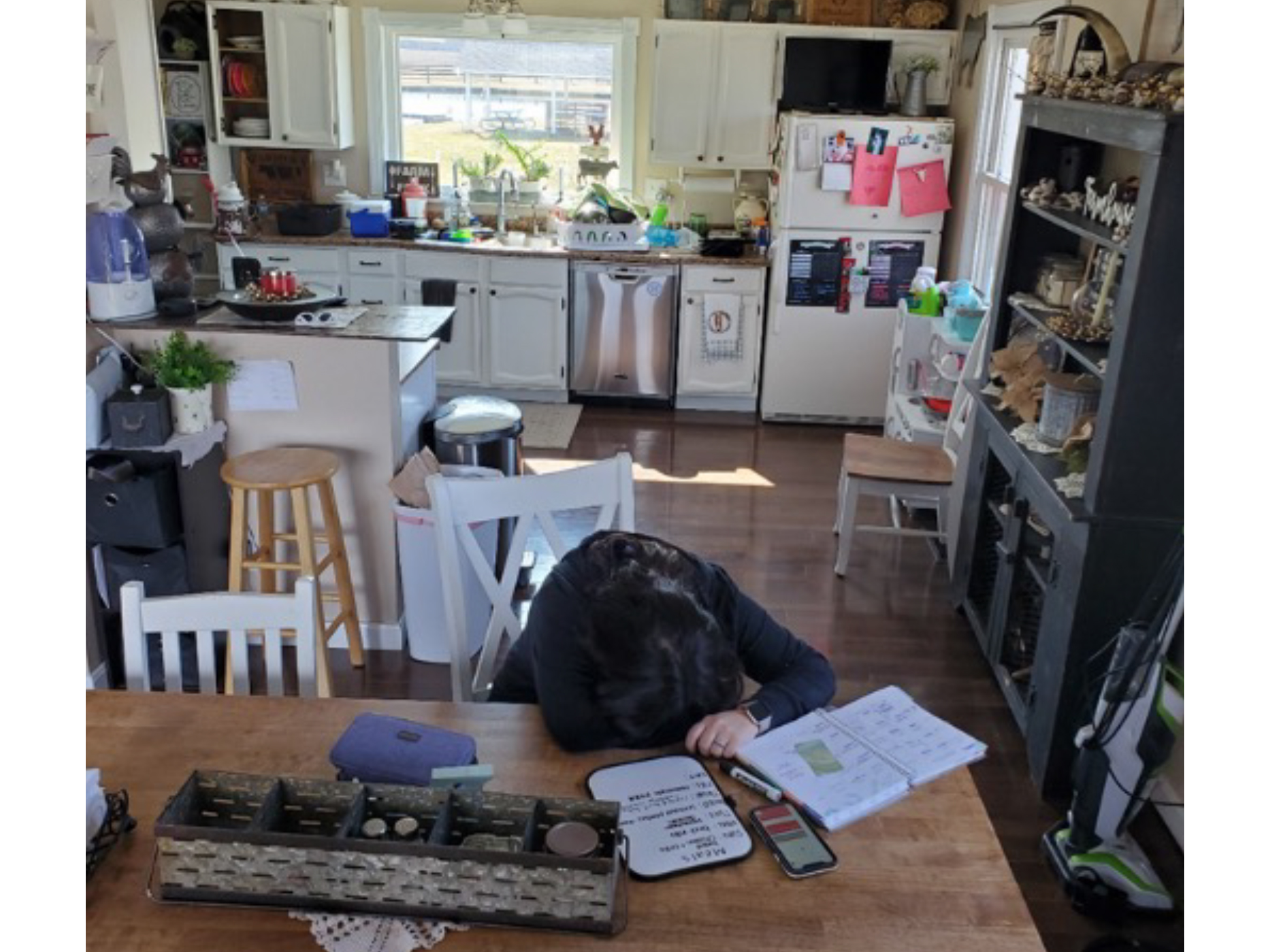Person slumped over table in kitchen
