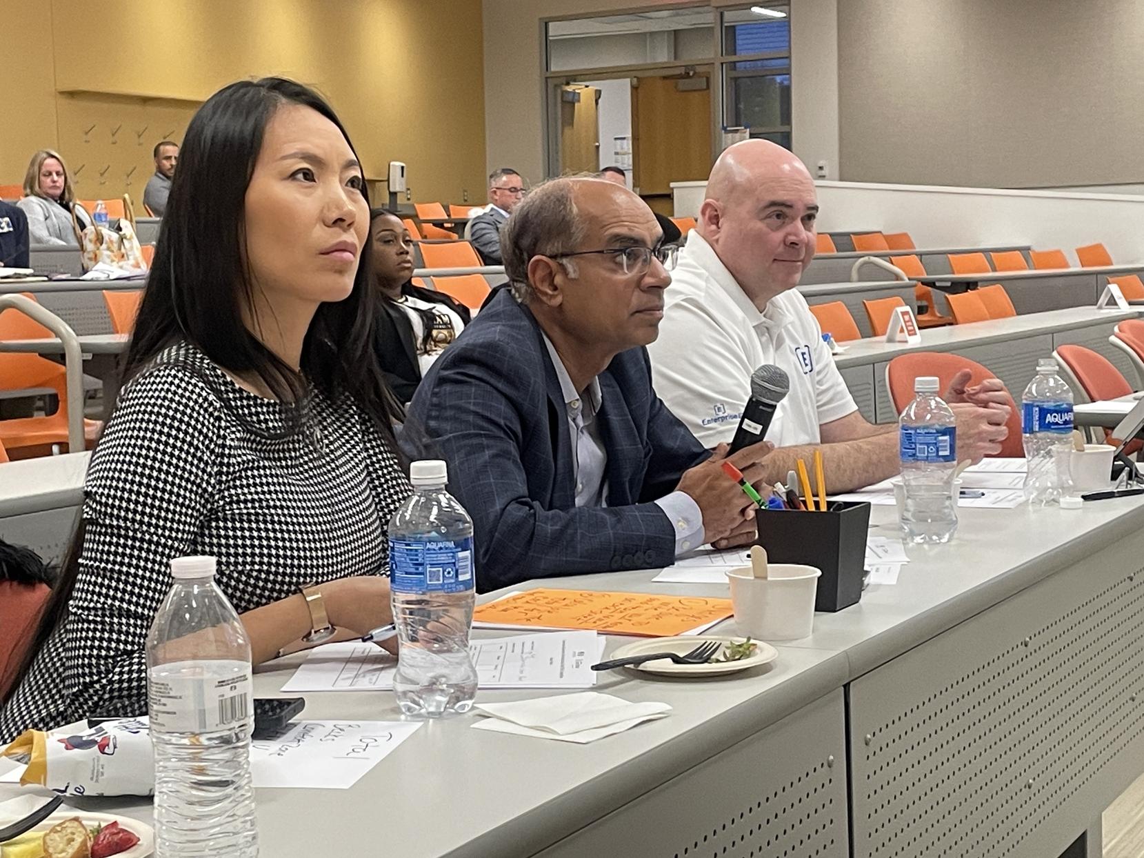 Three judges sit behind a table, listening to business pitches