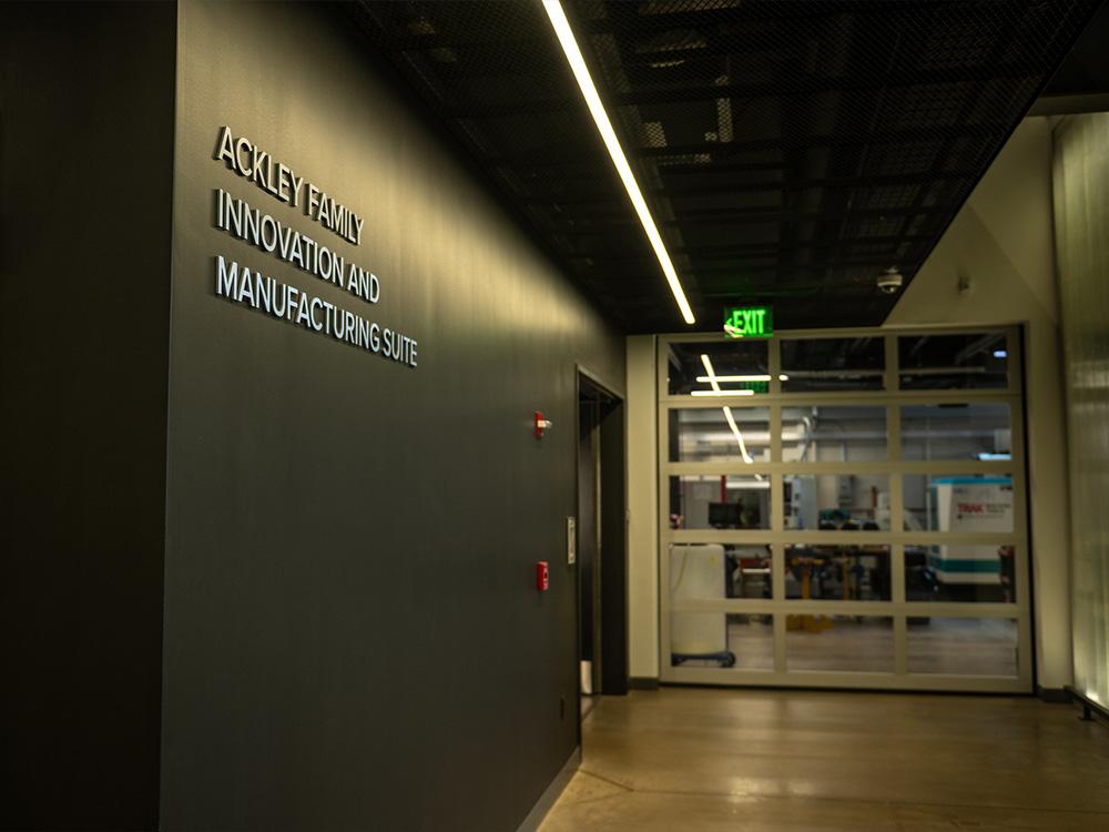A sign on the wall that reads "Ackley Family Innovation and Manufacturing Suite" 