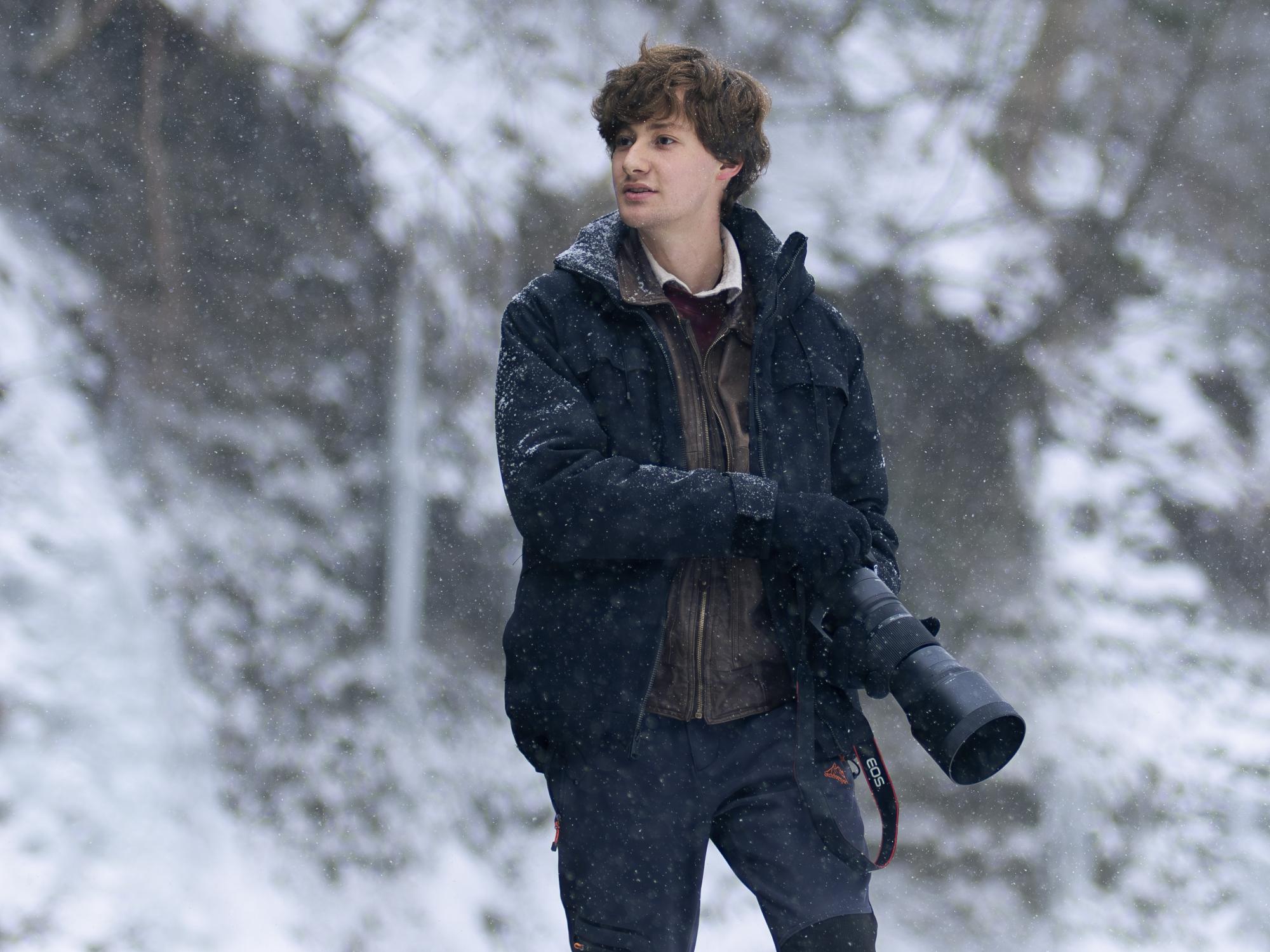 An environmental portrait of Jordan DeLauer, a Penn State Behrend student, holding a camera.