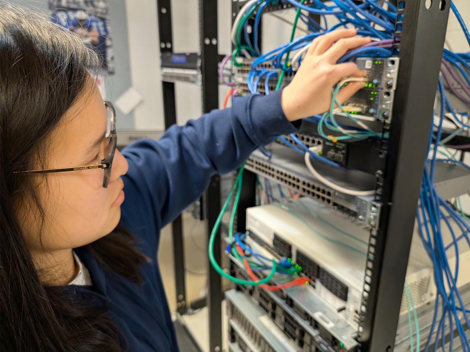 Penn State DuBois student Katy Fritz connects one of the enterprise-class virtualization servers to the network system in one of the IST labs at Penn State DuBois.