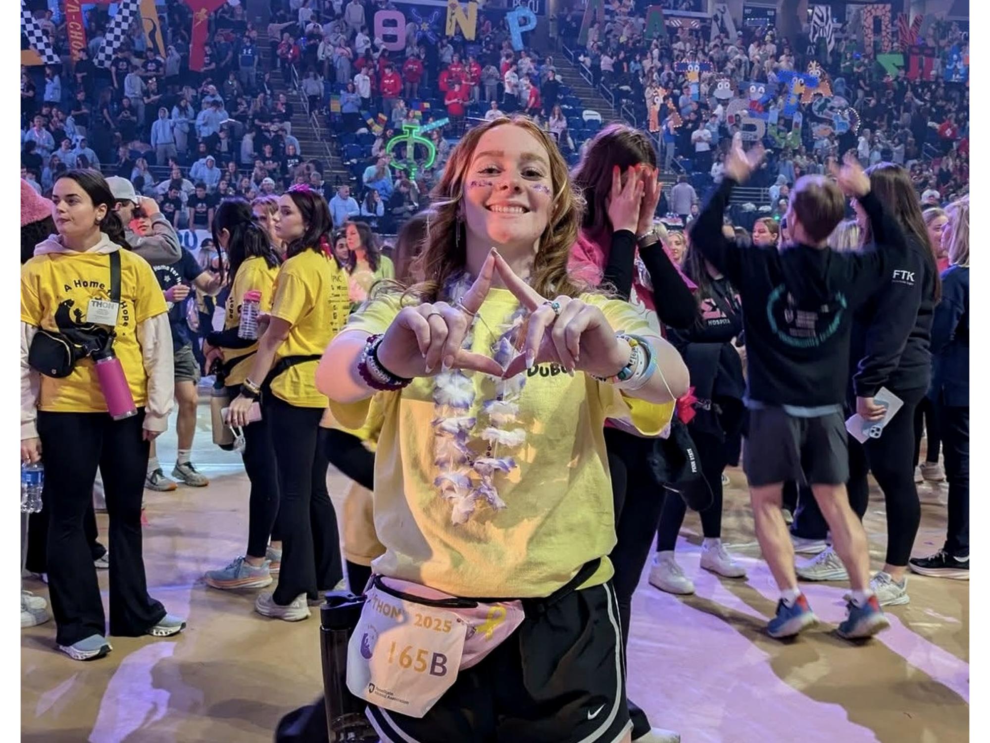 Penn State DuBois student Amber Eberly stands on the dancefloor at the Bryce Jordan Center during THON 2025.