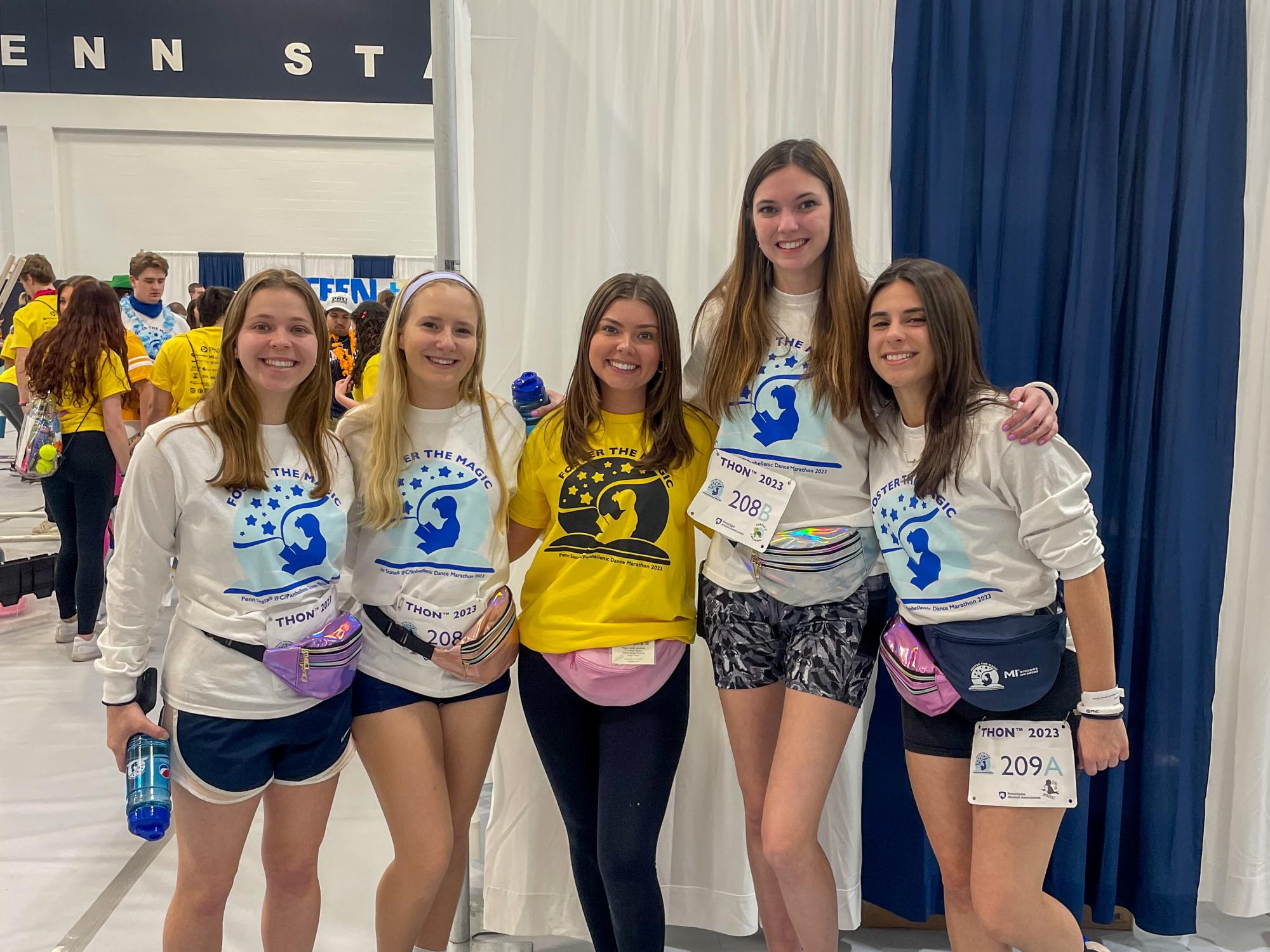 Arnoldi (left) poses with three THON dancers and a dancer relations committee member in the South Annex of the Bryce Jordan Center during THON 2023.