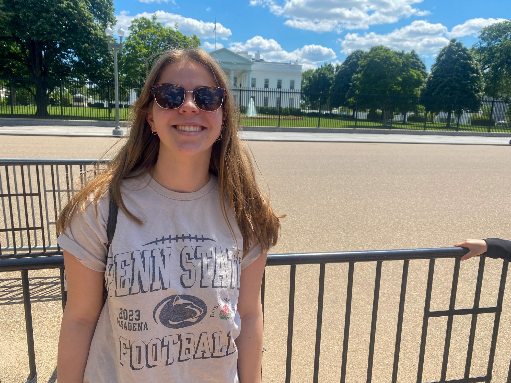 Cara Arnoldi smiles while wearing a Penn State T-shirt in front of the White House in Washington D.C.