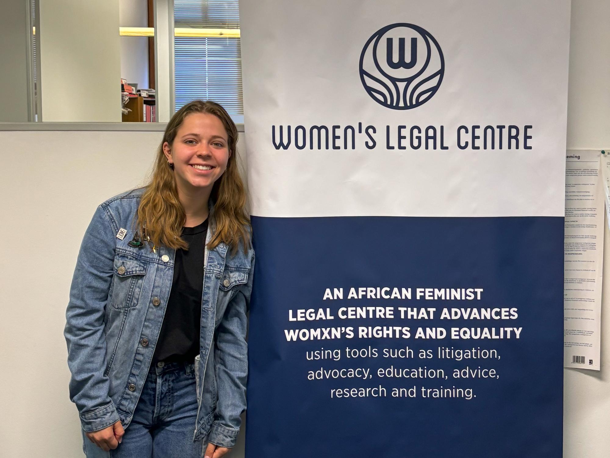 Cara Arnoldi poses with a banner for the Women’s Legal Centre in South Africa.