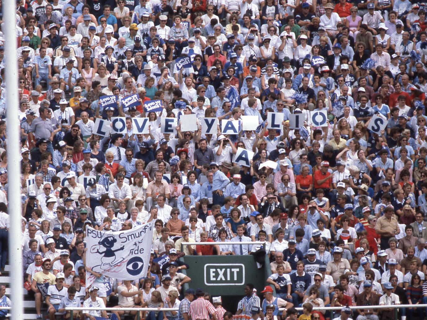 Fans hold "Love Ya Lions" signs and placards in the stadium stands