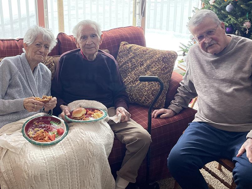 From left: a woman and a man sitting on a couch and a man sitting on a chair.