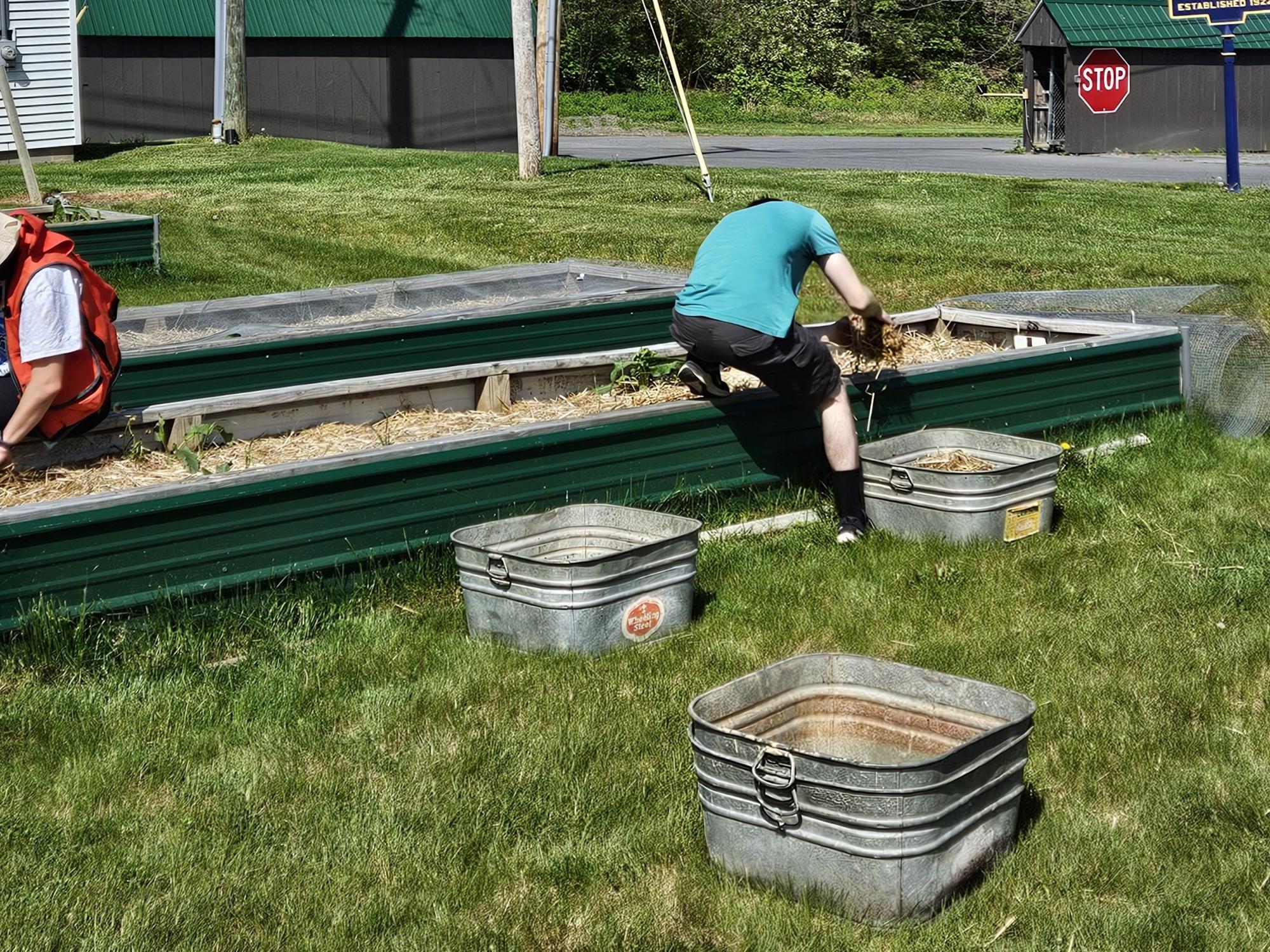 Students working in a raised planter bed outside. 
