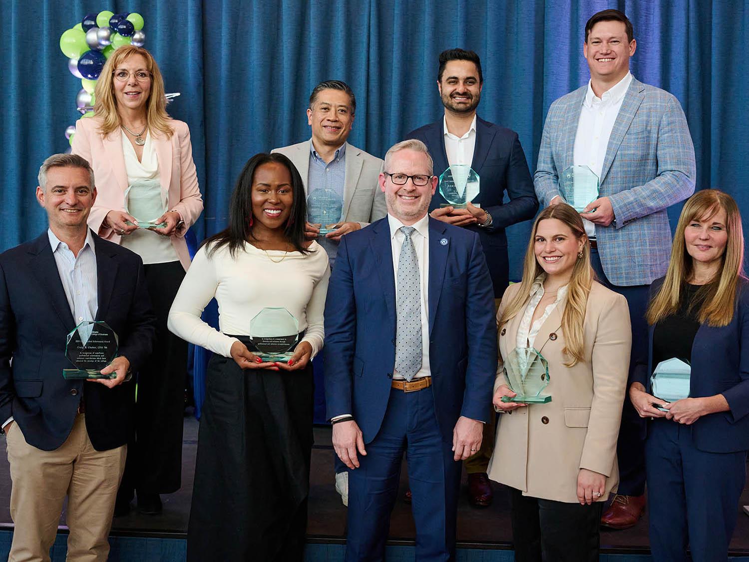 A group shot of four women and five men who received Alumni Awards.