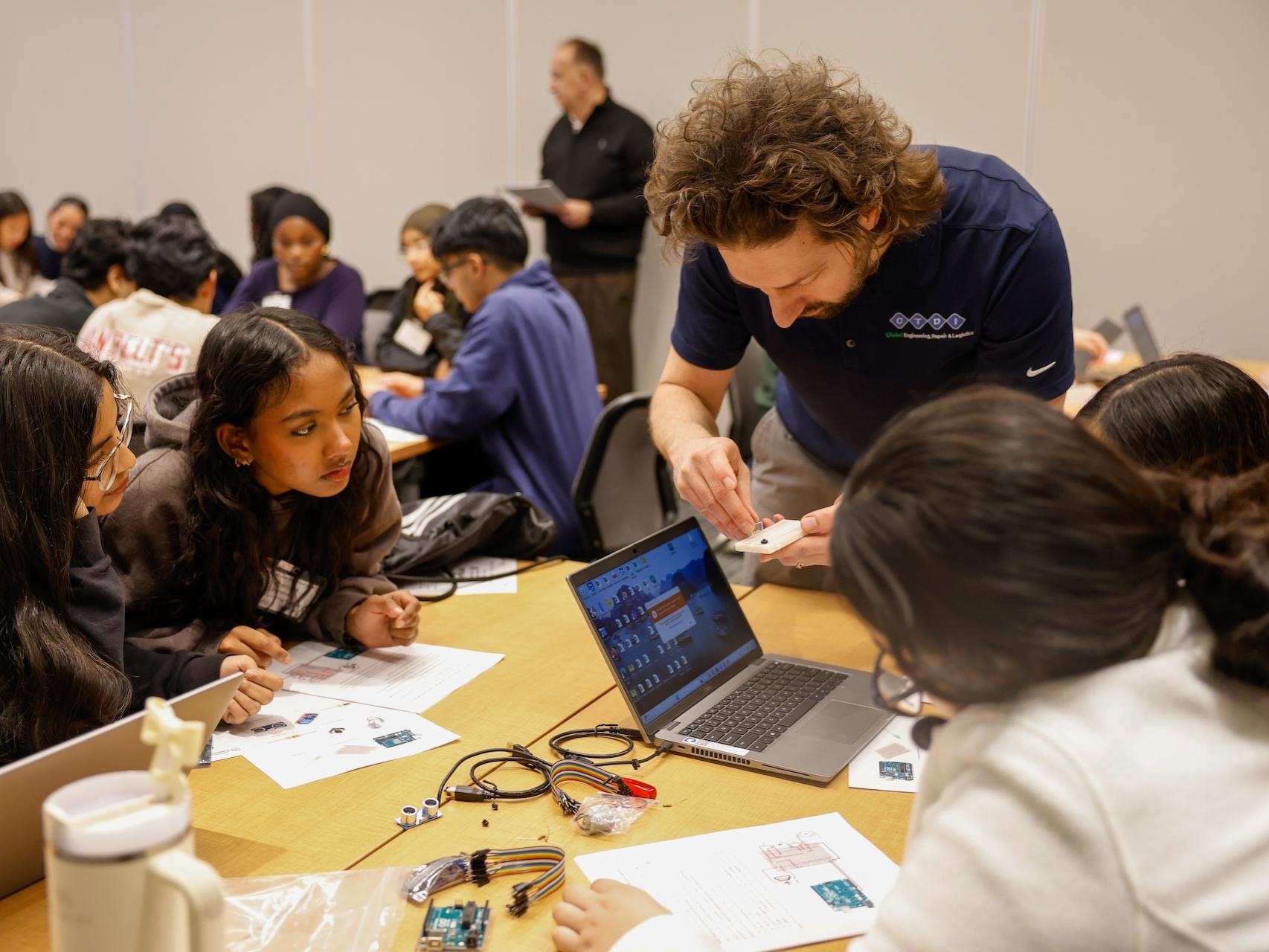 man helping students with workshop