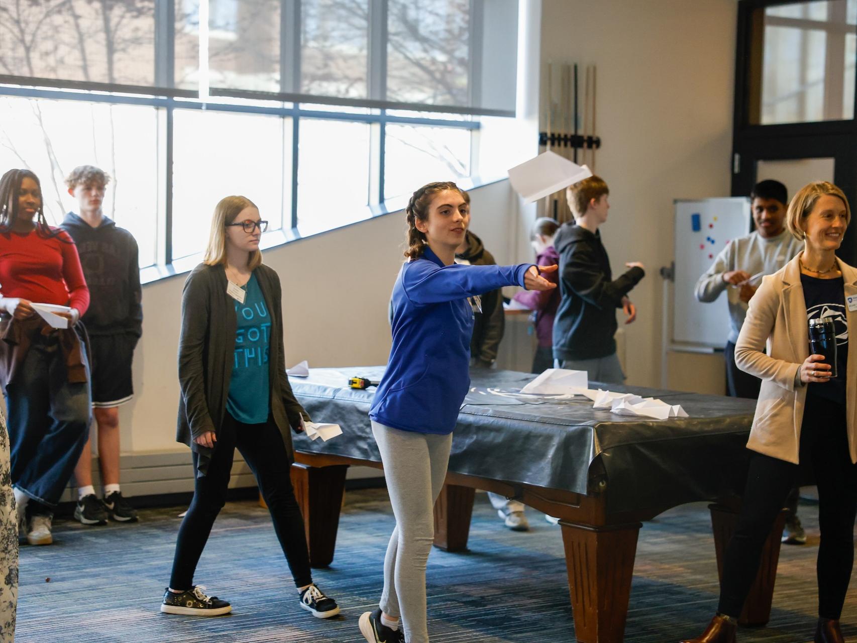 student flying paper airplane