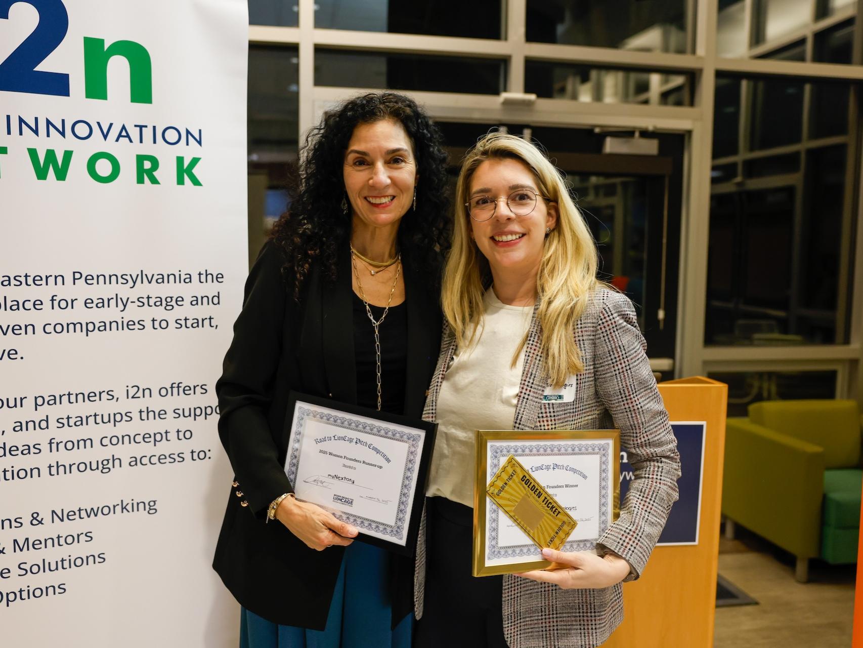 two ladies holding certificates