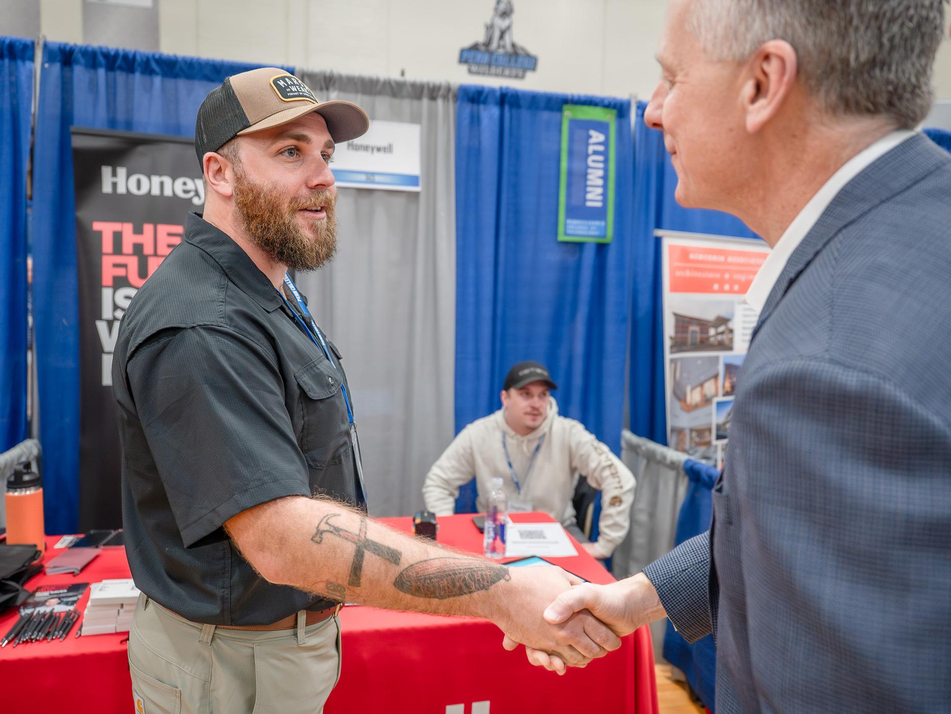 Two men clasp hands in greeting