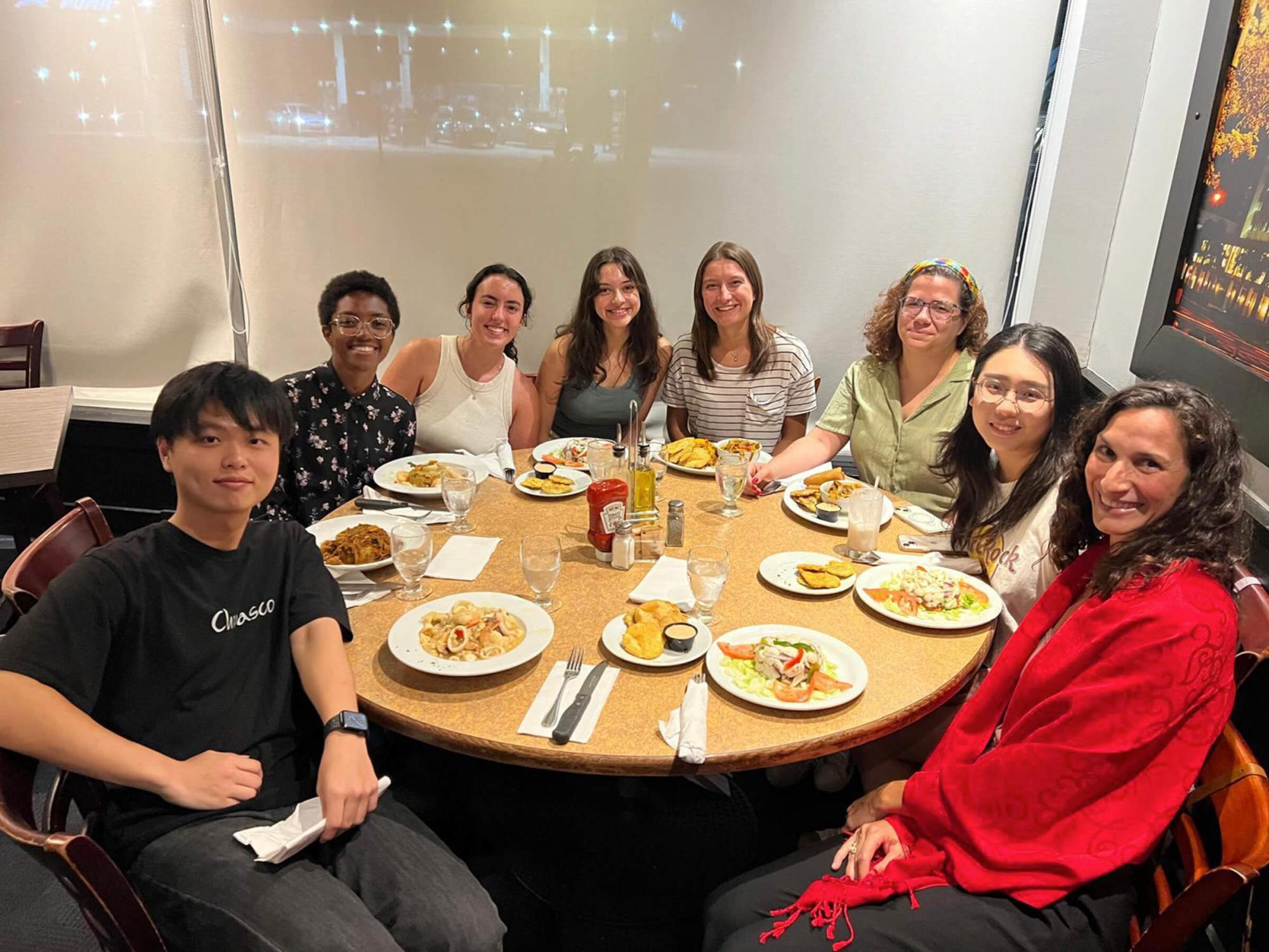Anna Raquel Duiker (fourth from right) sits at a dinner table in a restaurant with faculty and students from Penn State during her PIRE program experience in Puerto Rico.