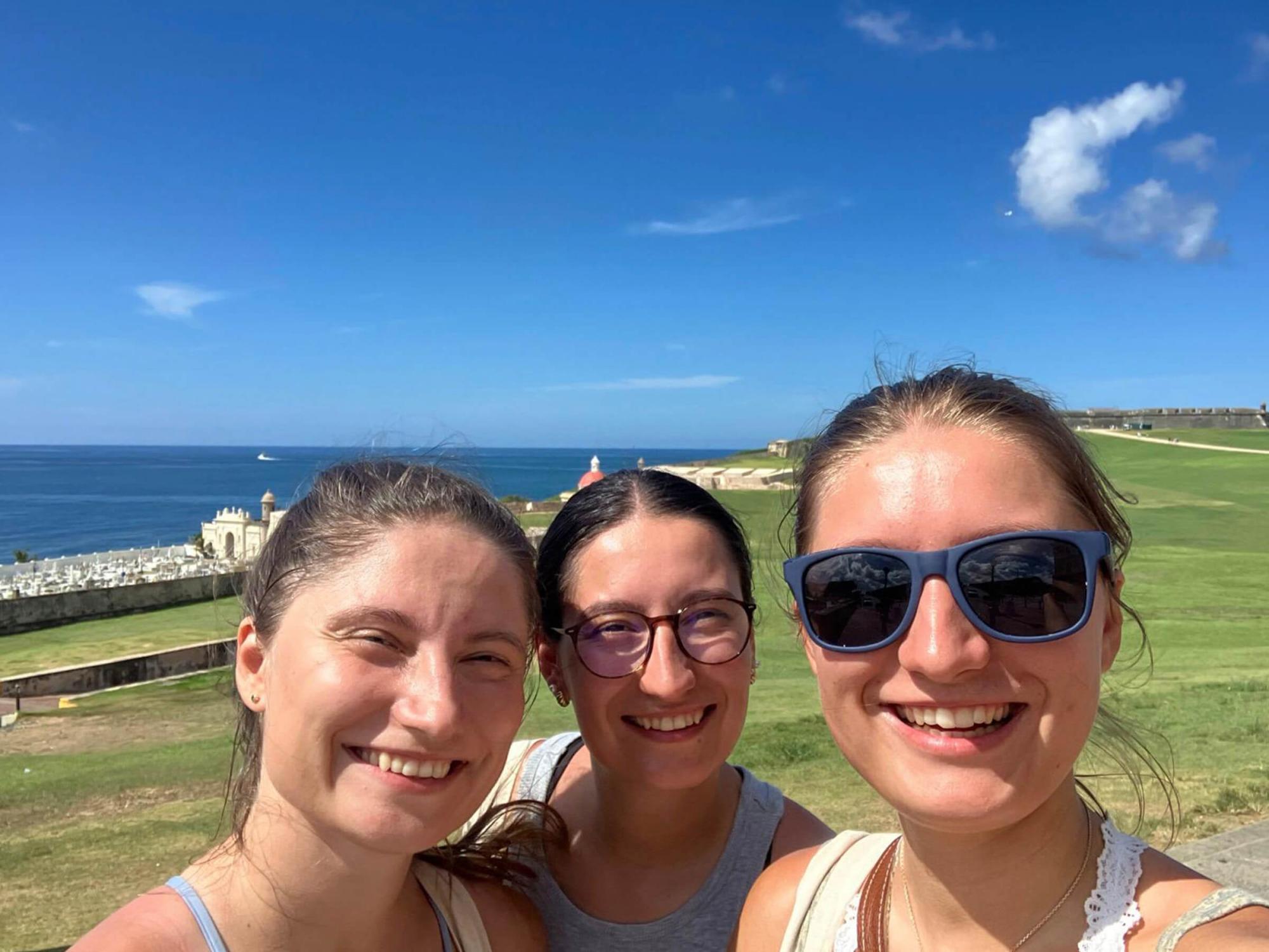 Lina Ruth Duiker (left), Maria Rebecca Duiker (middle), and Anna Raquel Duiker (right) take a selfie with the ocean behind them in Viejo San Juan, Puerto Rico.
