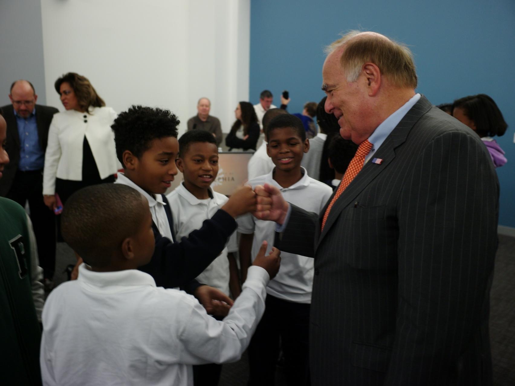 Ed Rendell shares fist bump with  a group of students