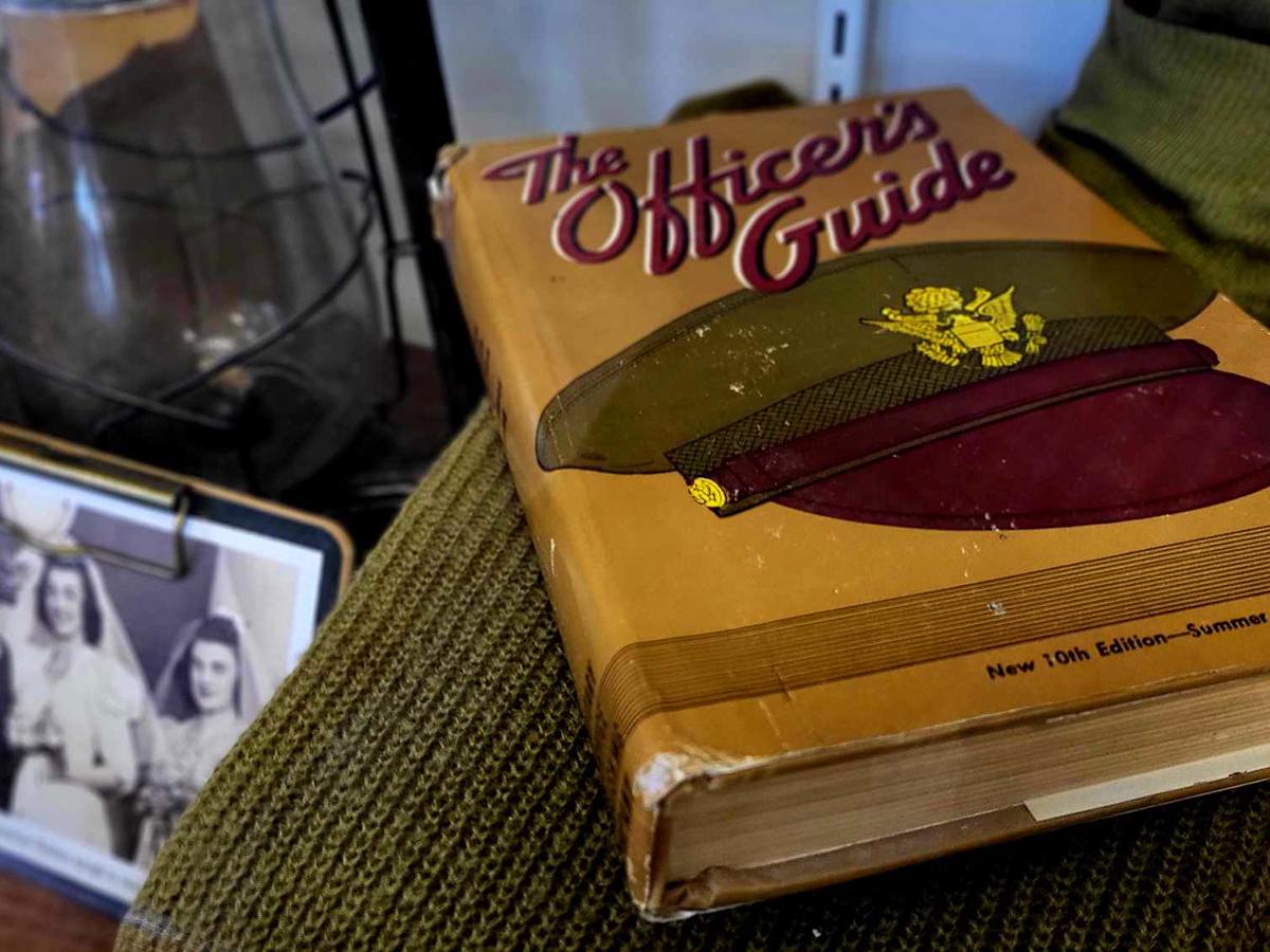 Personal items belonging to John C. Halloran now on display in the Smith Building, including a book titled The Officer's Guide and a wedding photo.