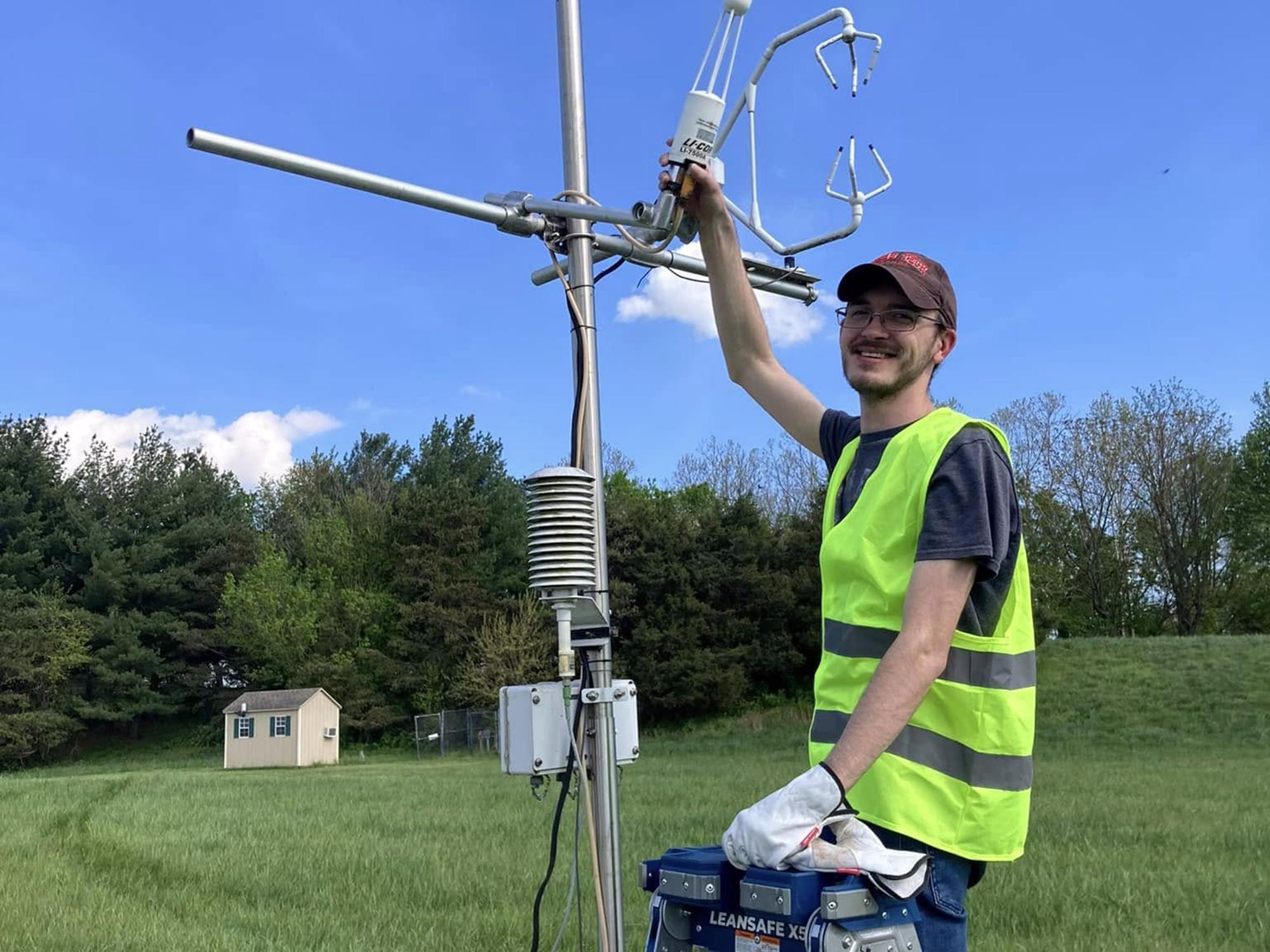 Nicholas Prince stands next to flux tower instrument