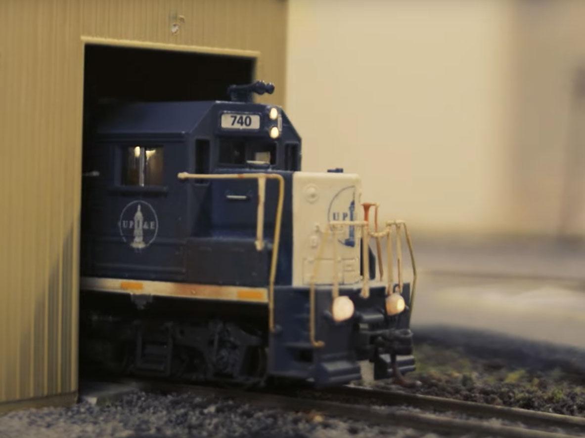 A model train engine marked with the Old Main dome in white paint