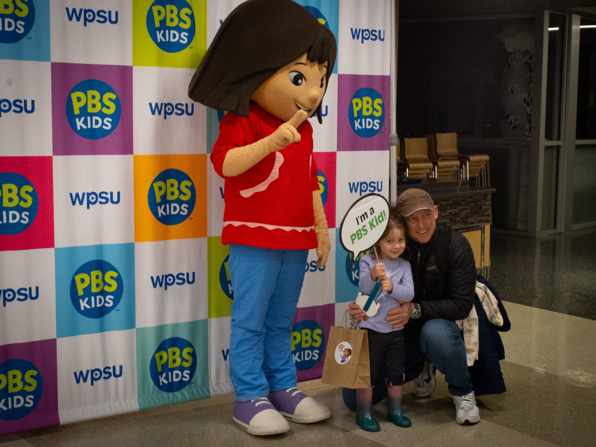An adult and child pose for a photo with PBS Kids Molly of Denali